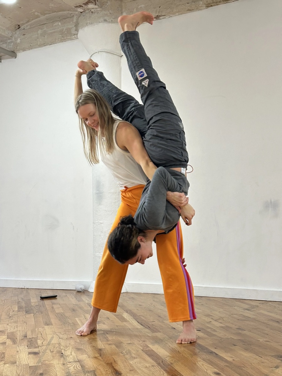 Leighann Kowalsky smiling while supporting a dancer during movement practice.