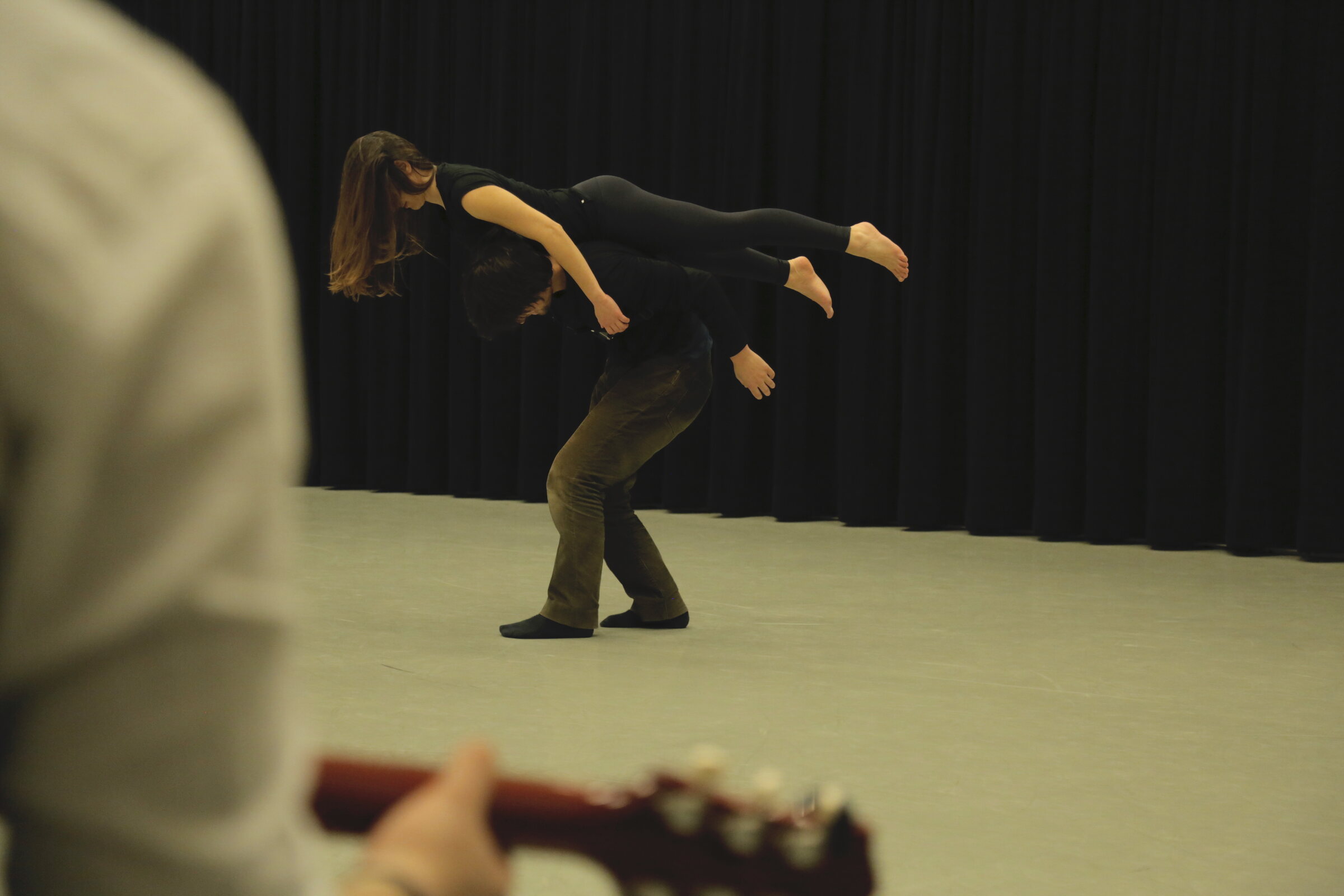 Two Contact Improvisation dancers sharing weight while moving through the air.